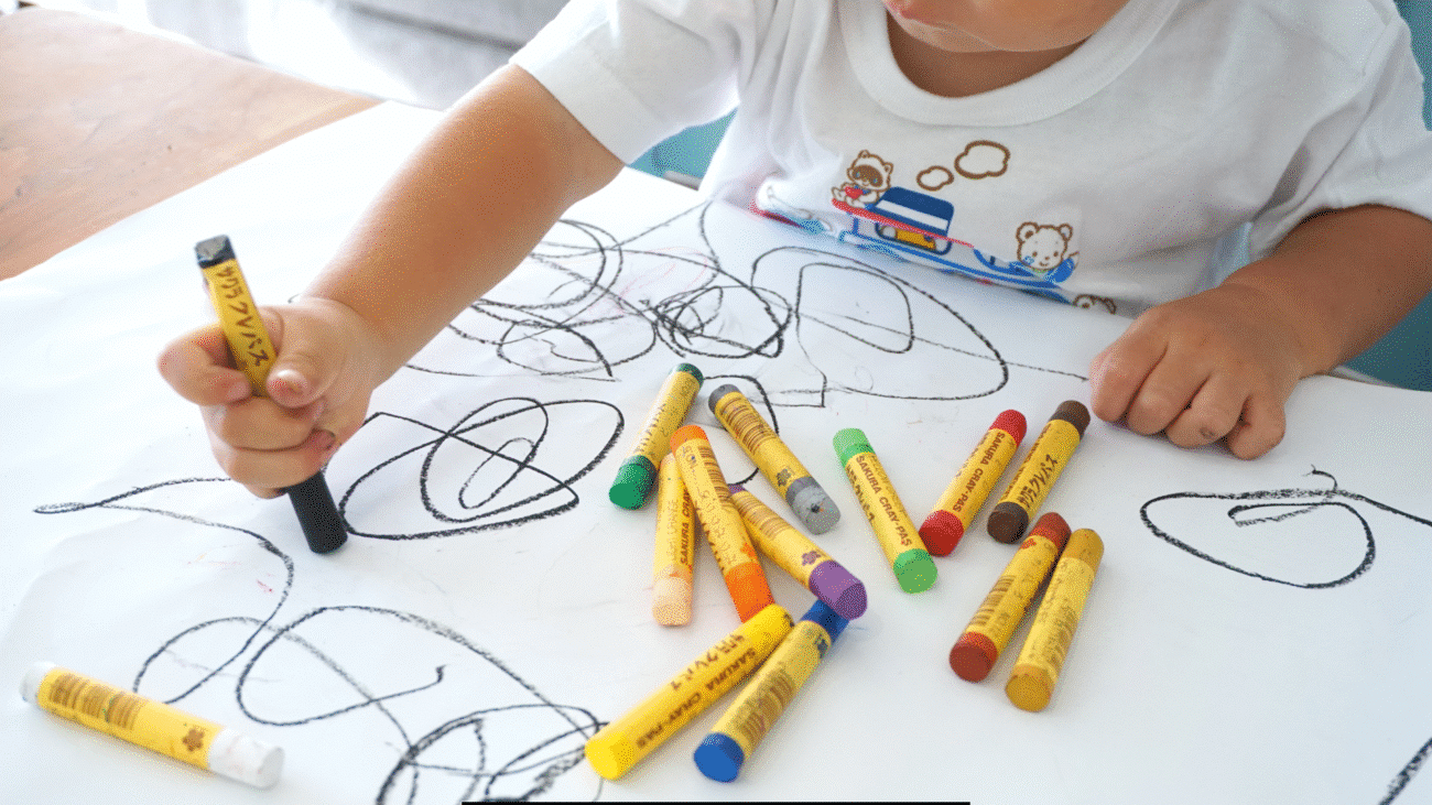 un enfant dessinant avec des crayons de couleur